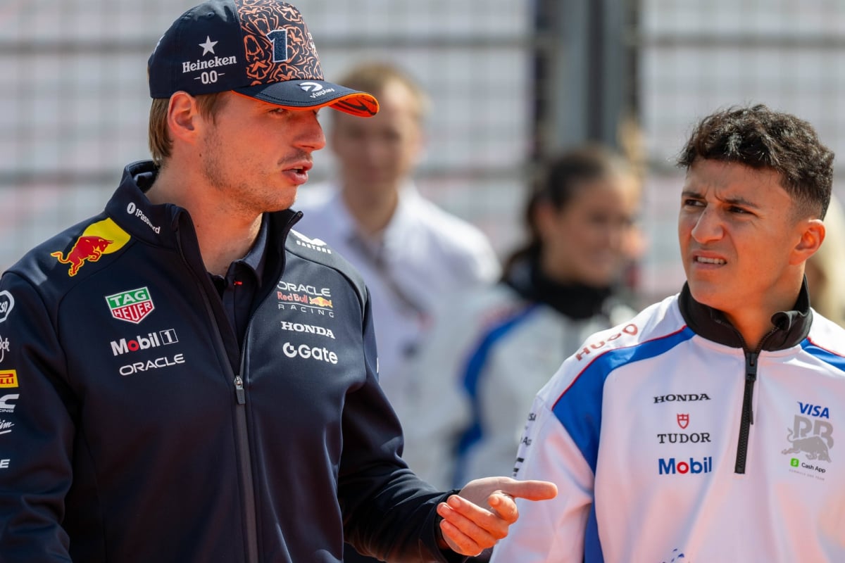 Verstappen and Hadjar mid-discussion on a paddock walk