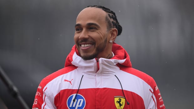 Lewis Hamilton smiling from ear to ear in 2026 red and white Ferrari F1 windbreaker