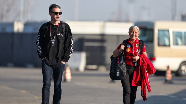 Hynes and Cullen walking through Chinese GP car park together, Hynes in black clothing, Cullen in Ferrari kit
